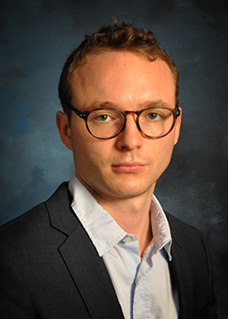 headshot of Sundesh Khalsa, light skinned male wearing glasses