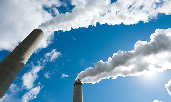 smoke stacks in front of blue sky