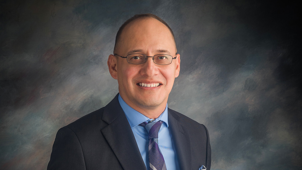 Joaquin Baca, middle aged man with glasses dressed professionally